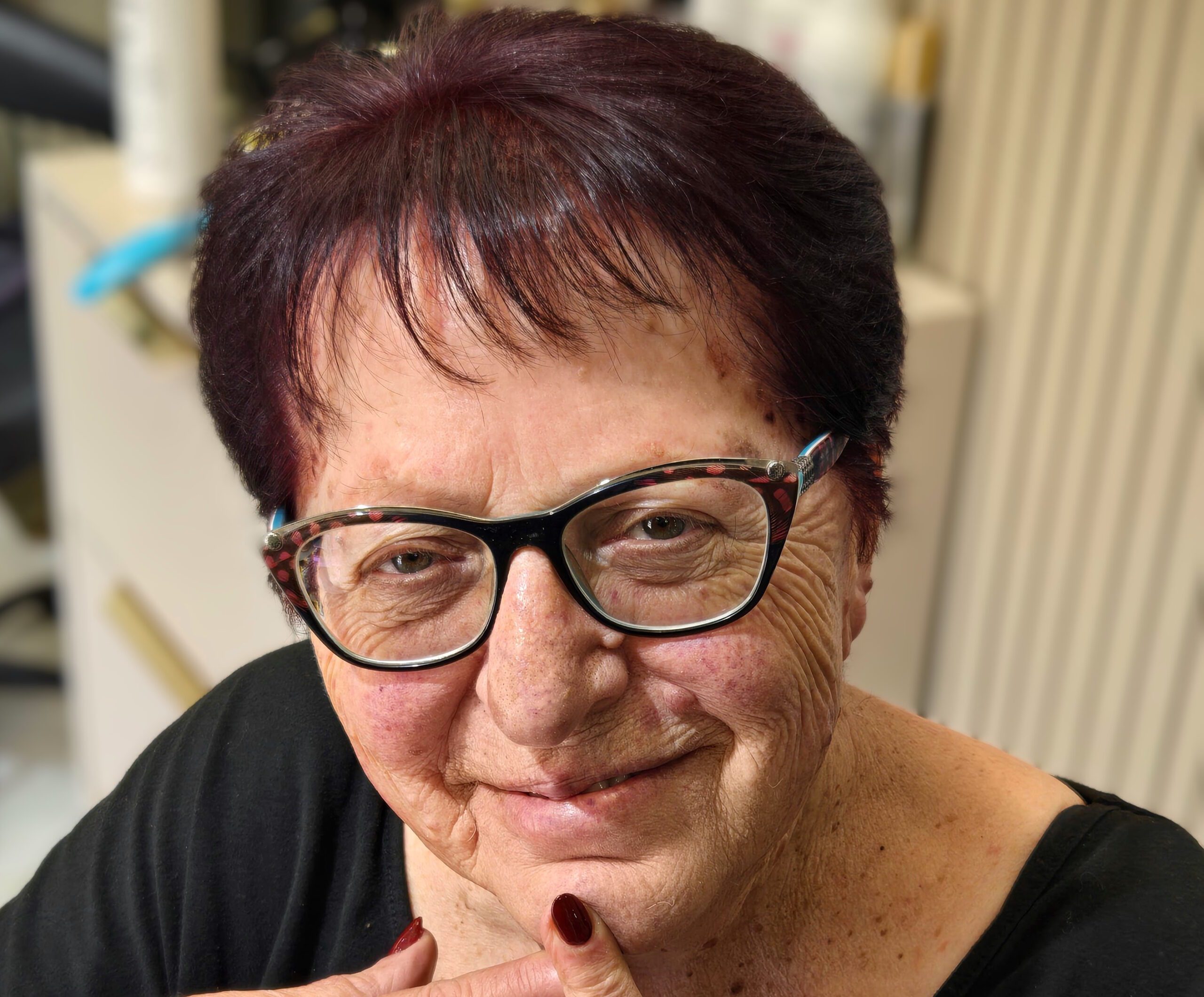 Gila, founder of Ageless Revenue, smiling at her desk.